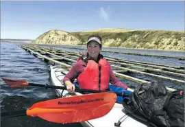  ?? Allen J. Schaben Los Angeles Times ?? AMY TRAINER, deputy director of the California Coastal Protection Network, kayaks past oyster racks in Drakes Estero at Point Reyes National Seashore.