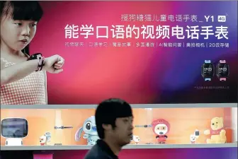  ?? PROVIDED TO CHINA DAILY ?? A visitor walks past a billboard advertisin­g Sogou Teemo kids smart watches at CES Asia in Shanghai on June 13, 2019.