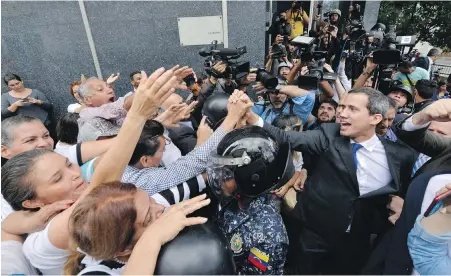  ??  ?? Venezuelan opposition leader Juan Guaido greets supporters as he leaves the National Assembly in Caracas on Tuesday.