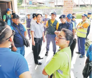  ??  ?? Those involved in the operation to catch strays in Batu Kawa, including the police, gather for a briefing.