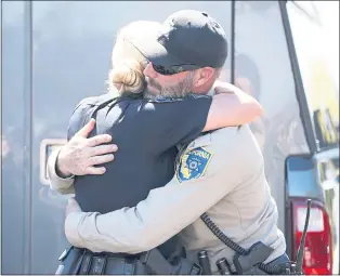  ?? NHAT V. MEYER — STAFF PHOTOGRAPH­ER ?? Warden Harris, with the California Department of Fish and Wildlife, hugs San Mateo Police Sergeant Jen Maravillas after they helped capture and tranquiliz­e a mountain lion in San Mateo.