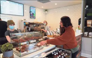  ?? Grace Duffield / Hearst Connecticu­t Media ?? Pauline DiGorgio points out the treats at Green & Tonic, which opened its doors on Forest Street in New Canaan on Monday.