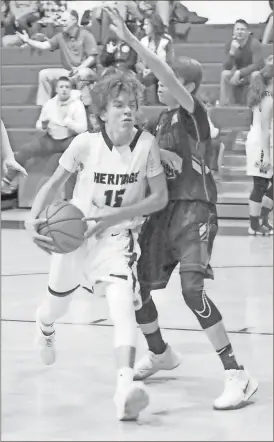  ??  ?? Heritage’s Kaden Swope drives the lane against Ringgold’s Brevin Massengale during last week’s home game against the rival Tigers. (Photo by Scott Herpst)