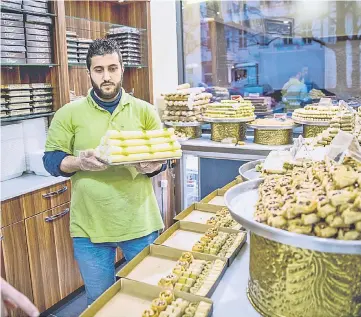  ??  ?? An employee is seen working in the ‘Konditorei Damaskus’ pastry shop. The exiled pastry chef who ran a big bakery in his war-torn city of Homs in Syria, fled to Germany with his family and set up his business in the German capital. — AFP photos