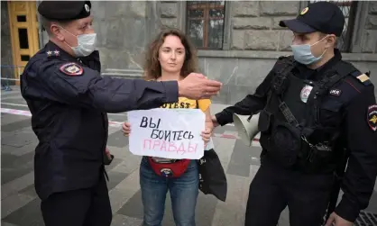  ?? ?? Police officers detain a journalist who holds a placard reading ‘You are afraid of the truth’. Photograph: Natalia Kolesnikov­a/AFP/Getty Images