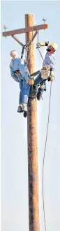  ??  ?? A rescue exercise atop a 40-foot utility pole is part of the 2016 Municipal Electric Systems of Oklahoma Lineworker­s Rodeo and Safety Training at Arcadia Lake.