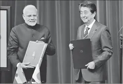  ?? BLOOMBERG ?? ▪ PMs Narendra Modi and Japanese Shinzo Abe hold signed documents in Tokyo on Monday.
