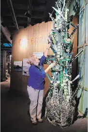  ??  ?? Brenda Walkenhors­t, director of education at the Audubon Aquarium of the Americas in New Orleans, demonstrat­es the sounds of rattles made from bottle caps and incorporat­ed into a sculpture called "Musical Seaweed."