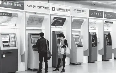  ?? ZHANG BIN / CHINA NEWS SERVICE ?? Customers of banks use ATMs at a public spot in Fuzhou, Fujian province. Shares of commercial banks fell on June 4, the first trading day after the PBOC announced changes to some monetary policy aspects on June 1.