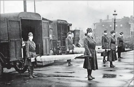  ?? LIBRARY OF CONGRESS ?? Wearing protective masks, members of the St. Louis Red Cross Motor Corps are seen on duty in October 1918 at the height of the pandemic.