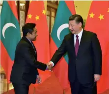  ??  ?? Photo ci-contre : Le 7 décembre 2017, le président des Maldives Abdulla Yameen Abdul Gayoom (à gauche) est reçu à Pékin par le président chinois Xi Jinping, une visite au cours de laquelle il signe avec la Chine un accord de libre-échange. Depuis l’arrivée au pouvoir de l’actuel président, les Maldives ont effectué un virage radical vers la Chine, qu’elles intéressen­t à plus d’un titre. Situées sur une route maritime stratégiqu­e, où transitent la moitié des porte-conteneurs au monde, les Maldives sont intégrées à l’initiative chinoise des « nouvelles routes de la soie ». (© Presidency.gov.mv)