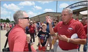  ?? NWA Democrat-Gazette/ANDY SHUPE ?? Arkansas Coach Dave Van Horn (left) speaks with former Razorbacks football Coach Ken Hatfield on Friday as fans welcomed back the UA baseball team at Baum Stadium in Fayettevil­le.