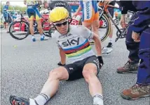  ??  ?? Big blow: World champion Mark Cavendish sits stunned on the road after crashing in a pile-up 3km from the finish line.