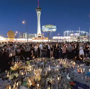  ?? PHOTO AFP ?? Plusieurs personnes se sont rassemblée­s dimanche soir près des lieux du drame en mémoire des victimes abattues lors d’un concert à Las Vegas.