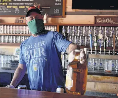  ?? Will Waldron / Times Union ?? Carl Lewandowsk­i is the manager of Wolff’s Biergarten in Albany. Owner Matt Baumgartne­r instituted a cash-only policy but likely will accept credit cards when his business reopens, he said.
