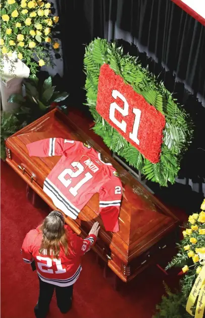  ?? GETTY IMAGES ?? A fan puts her hand on Hawks legend Stan Mikita’s casket during a public visitation for him Sunday at the United Center.
