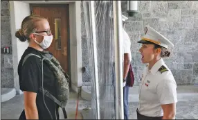  ?? (AP/Mark Lennihan) ?? A new cadet (left) listens as First Class Cadet Madison Teague yells commands from the other side of a plastic screen Monday at the U.S. Military Academy in West Point, N.Y.