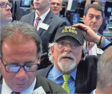  ?? RICHARD DREW, AP Trader Peter Tuchman has the Dow milestone at the top of his mind Wednesday at the New York Stock Exchange. ??