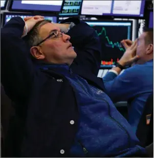  ?? (AP/Richard Drew) ?? Traders watch stocks fall Thursday from their booths on the floor of the New York Stock Exchange.