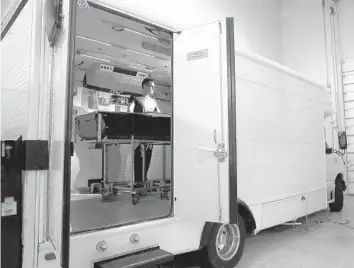  ?? CARLINE JEAN/SOUTH FLORIDA SUN SENTINEL ?? Sayer Johanson, operations manager for Suspended Animation Inc. in Boynton Beach, works with a dummy inside one of the vehicles that provide transporta­tion for people who want their bodies frozen and preserved.