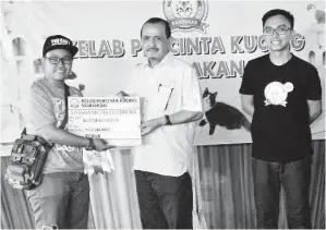  ??  ?? JUHARI menyampaik­an hadiah kepada pemenang Best of the Best Local Cat kepada seorang pemilik kucing.