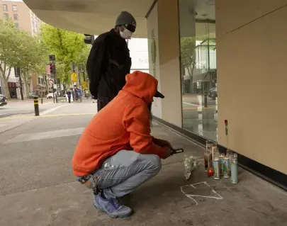  ?? Rich Pedroncell­i, The Associated Press ?? A person who says he is a relative of one of Sunday’s mass shooting victims kneels at a memorial near the scene of the shooting in Sacramento, Calif., on Monday.