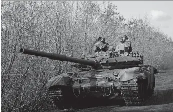  ?? EVGENIY MALOLETKA/AP PHOTO ?? A Ukrainian tank drives Saturday toward frontline positions near Bakhmut.