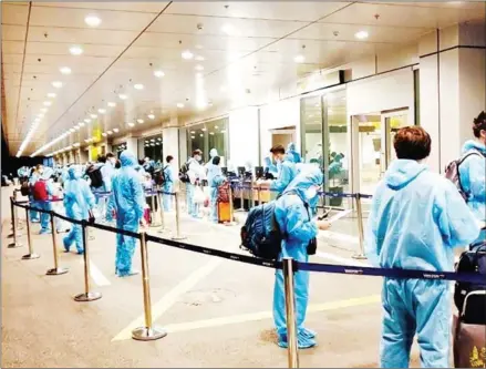  ?? VIETNAM NEWS AGENCY ?? Repatriate­d Vietnamese citizens at Van Don Internatio­nal Airport in Quang Ninh province wait to process their entry papers after landing, in August.