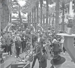  ?? ALEX GOULD/THE REPUBLIC ?? The crowd gathers before the menorah as they wait to light the first candle during the menorah lighting ceremony at the Scottsdale Quarter on Sunday.