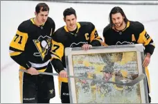  ?? AFP ?? Sidney Crosby (center) of the Pittsburgh Penguins poses with teammates Mike Matheson (right) and Evgeni Malkin to honor Crosby for his 1,000th NHL appearance prior to their home game against the New York Islanders on Saturday. Crosby is expected to star for Team Canada at the Beijing 2022 Winter Olympics.