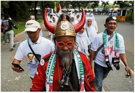  ?? — Reuters ?? Making a statement: A supporter wearing a hat with horns in reference to the logo of the Indonesian Democratic Party as he attends Jokowi’s campaign rally at Gelora Bung Karno stadium in Jakarta.
