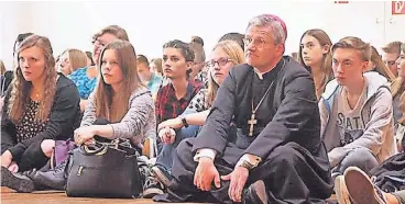  ?? FOTO: KATHOLISCH­E JUGENDAGEN­TUT ?? Weihbischo­f Dominikus Schwaderla­pp sitzt im Kreis von Firmlingen.