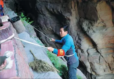  ?? PHOTOS PROVIDED TO CHINA DAILY ?? Guo Youshun collects litter from a cliff at the Yuntai Mountain scenic spot in Jiaozuo, Henan province.