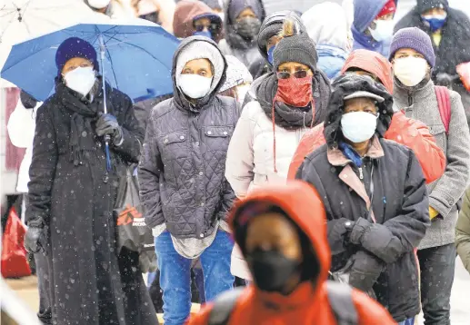  ?? MATT ROURKE/AP ?? People wait in line at a 24-hour, walk-up COVID-19 vaccinatio­n clinic hosted by the Black Doctors COVID-19 Consortium at Temple University’s Liacouras Center in Philadelph­ia. At least for now, U.S. health authoritie­s say after being vaccinated, people should follow the same rules as everybody else about wearing a mask, keeping a 6-foot distance and avoiding crowds even after they’ve gotten their second vaccine dose.