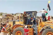  ?? Reuters ?? A Palestinia­n woman argues with an occupation soldier on an Israeli bulldozer in Khan Al Ahmar village near Jericho in the occupied West Bank yesterday.