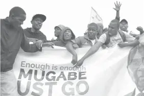  ?? AGENCE FRANCE PRESSE ?? People carry a banner and shout slogans during a demonstrat­ion demanding the resignatio­n of Zimbabwe's President Robert Mugabe.