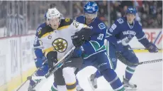  ?? THE CANADIAN PRESS ?? Bruins centre Riley Nash is checked by Canucks counterpar­t Henrik Sedin Monday during Boston’s 6-3 win at Rogers Arena.