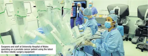  ??  ?? Surgeons and staff at University Hospital of Wales operating on a prostate cancer patient using the latest Da Vinci robotic surgery equipment