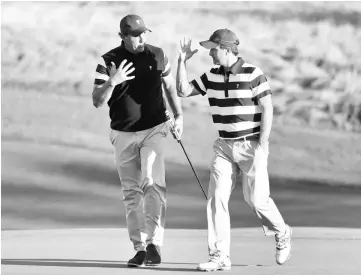  ??  ?? Phil Mickelson and Kevin Kisner of the US Team celebrate on the 17th green as they play against Marc Leishman and Jason Day of Australia and the Internatio­nal Team during Thursday foursome matches. — AFP photo