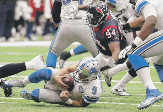  ?? | THOMAS B. SHEA/ GETTY IMAGES ?? The Texans’ Antonio Smith ( 94) sacks Lions quarterbac­k Matthew Stafford in the second quarter Sunday. The Lions failed to notch a fourth straight win.