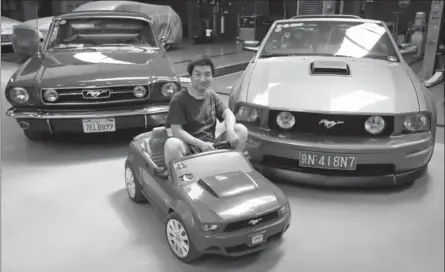  ?? ANDY WONG, THE ASSOCIATED PRESS ?? Guo Xin sits on a toy Mustang as he poses with his 1966 MT GT fastback, left, and 2005 GT convertibl­e at his garage in Beijing.
