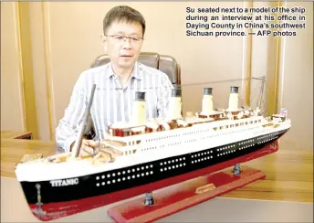  ?? — AFP photos ?? Su seated next to a model of the ship during an interview at his office in Daying County in China’s southwest Sichuan province.