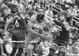 ?? Michael Wyke / AP ?? James Harden avanza hacia la cesta entre Jordans McLoughlin (6) y D'Angelo Russell en el triunfo de los Rockets sobre Minnesota, el martes, en Houston.