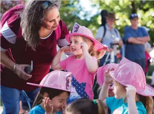  ?? OLIVIA HARLOW THE NEW MEXICAN ?? Trish Flores, a teacher at First Presbyteri­an Church, speaks with 4-year-old student Madelyn Barnes during a 9/11 memorial om the Plaza. Children from the preschool were just told it was an event to honor the firefighte­rs.