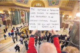  ?? MARK HOFFMANN/MILWAUKEE JOURNAL-SENTINEL ?? People protest the legislatur­e’s extraordin­ary session during the official Christmas tree lighting ceremony at the Capitol in Madison, Wis., on Tuesday.