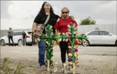  ?? Jay Janner/Austin American-Statesman via AP ?? Debra Ponce, left, and Angelita Olvera pray Tuesday in San Antonio where officials say dozens of people have been found dead and multiple others were taken to hospitals with heat-related illnesses after a semitraile­r containing suspected migrants was found.