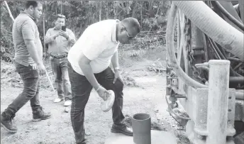  ?? ?? Minister of Housing and Water Collin Croal inspecting the well