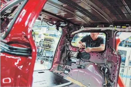  ?? GEOFF ROBINS THE CANADIAN PRESS FILE PHOTO ?? A worker installs parts on the production line at Chrysler's plant, in Windsor, Ont. The Canadian economy expanded at an annual pace of 1.7 per cent in the final months of 2017 as the more rapid growth seen earlier in the year faded further.