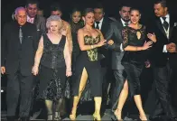  ?? EITAN ABRAMOVICH / AGENCE FRANCE-PRESSE ?? Dancers Oscar Brusco (left) and Nina Chudoba (second left) walk to the stage during the Tango World Championsh­ip in Buenos Aires, Argentina, last week.