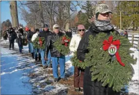  ?? PETE BANNAN – DIGITAL FIRST MEDIA ?? Volunteers line up to place wreaths on the mass grave at the Paoli Battlefiel­d Memorial Grounds.